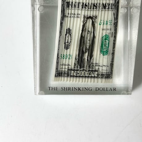 USED 70'S "THE SHRINKING DOLLAR" RIPPLED BILL PAPERWEIGHT