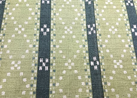 （端側日焼け変色）緑色のミンサー柄（いつ（五つ）の世（四つ）までも）の紅型（びんがた）布。大きい柄の沖縄柄綿生地。Made in JAPAN