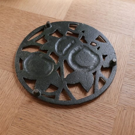 Iron trivet with fruit motif