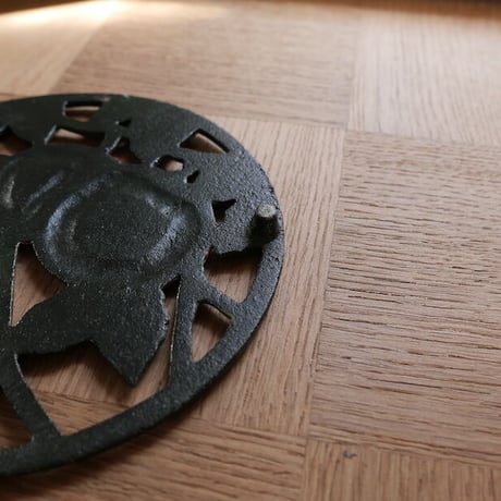 Iron trivet with fruit motif