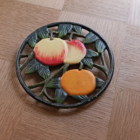 Iron trivet with fruit motif
