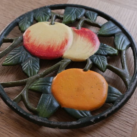 Iron trivet with fruit motif