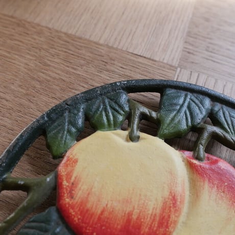 Iron trivet with fruit motif