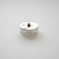 シルバーの蓋の付いたガラスの入れもの