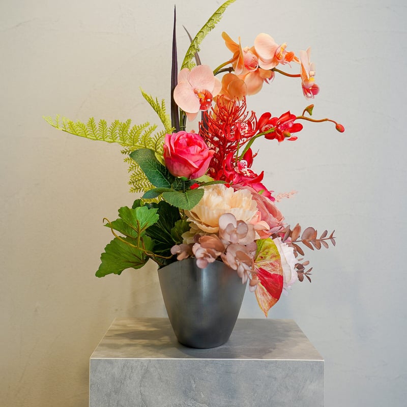 高級 造花 蘭 ピンクオレンジのビビットなアレンジメント 黒オーバル鉢