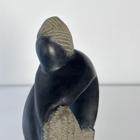 black stone object person sitting 80-90s