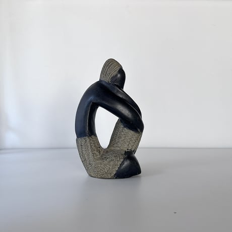 black stone object person sitting 80-90s