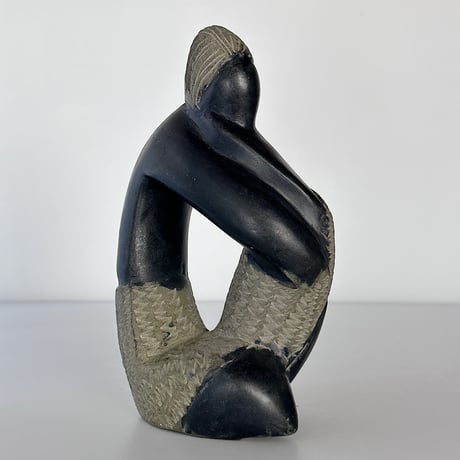 black stone object person sitting 80-90s