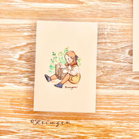 26K-25 "A child sitting and reading" postcard（「座って読書をする子」ポストカード）