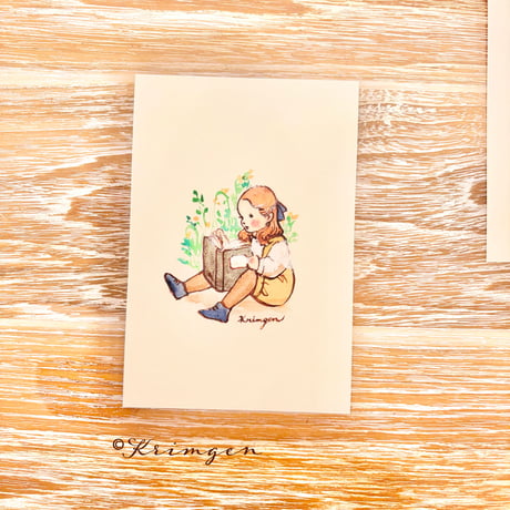 26K-25 "A child sitting and reading" postcard（「座って読書をする子」ポストカード）