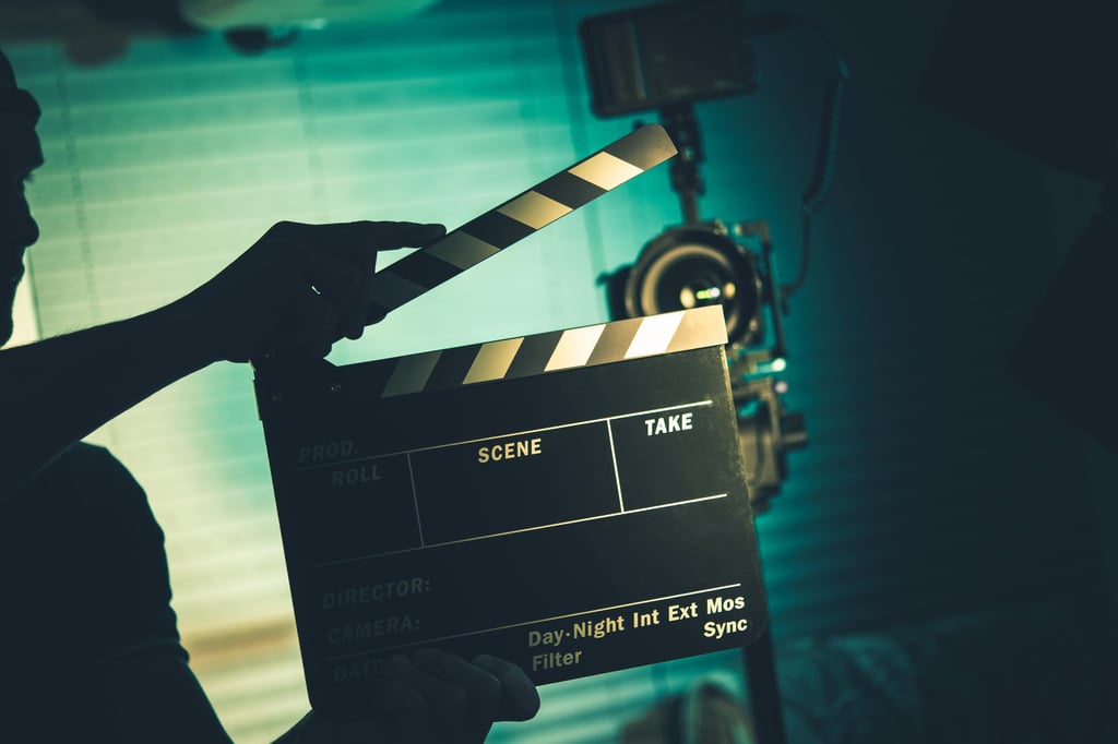 Ein Regisseur hält eine Filmklappe vor einer Kamera – hochwertige Produktion und professionelle Standards in der Erotikbranche.