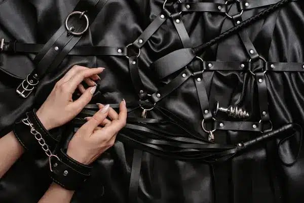 BDSM Zubehoer mit Fesseln Harness und Peitsche