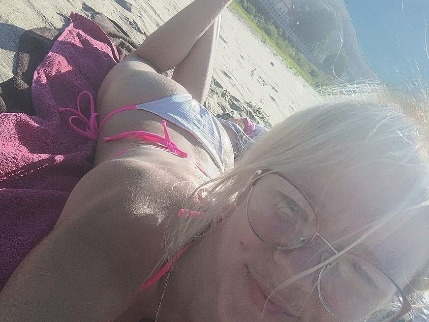 LeniFuchs entspannt in der Sonne, trägt einen blauen Bikini und genießt den Moment am Strand.