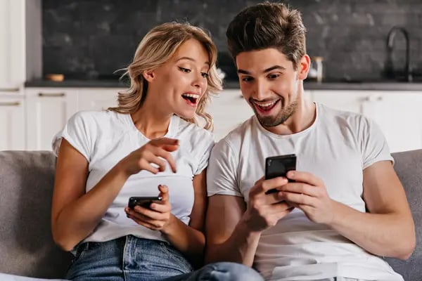 Paar chattet gemeinsam am Smartphone