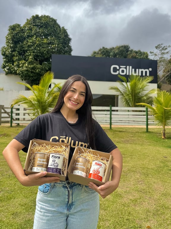 Integrante da equipe Cōllum com duas caixas de Super Colostro na fábrica, em São Fidélis (RJ)