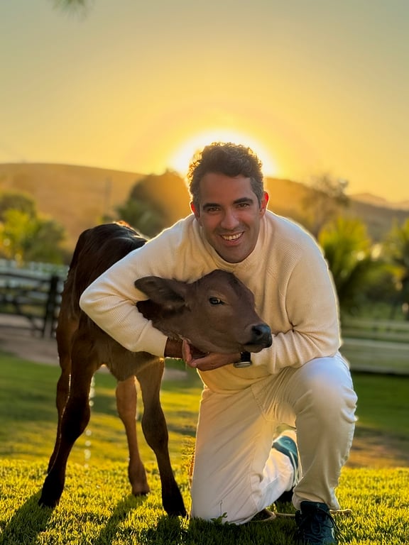 Jefferson abraçado ao recém-nascido no pôr do sol da fazenda