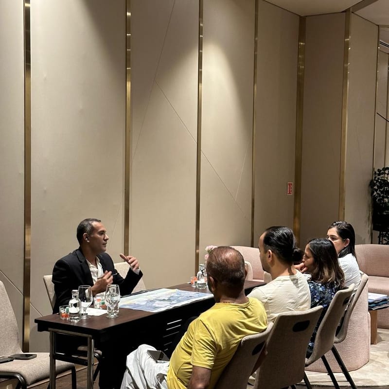 A Cube Realty advisor presenting Dubai project plans to a family of attendees