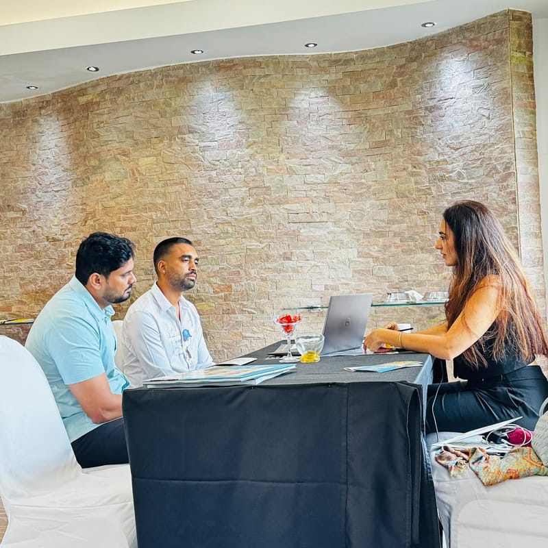 Two attendees reviewing a Dubai property shortlist with a Cube Realty advisor