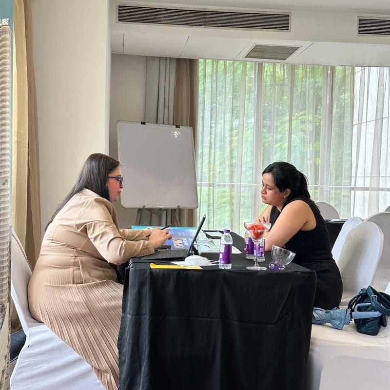 A Cube Realty advisor walking an attendee through project details on a laptop