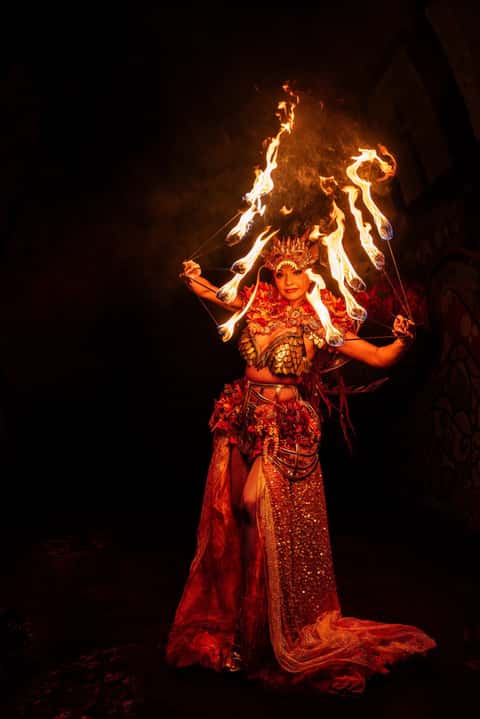 Fire performer with flame headdress, night