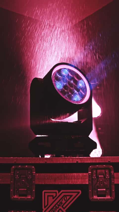 Chauvet Maverick Storm 2 IP65 moving head under simulated rain, pink and amber light