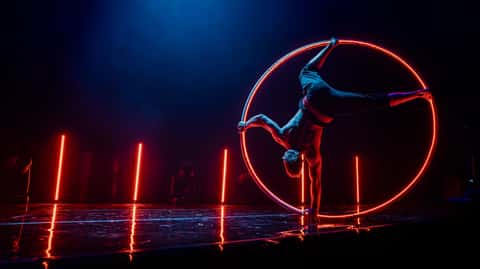 Cirque Bon Bon ground act under deep blue stage beams