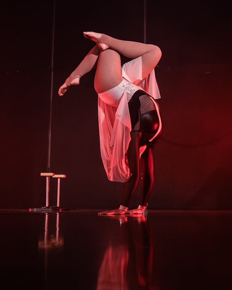 Pole and contortion performer alternate frame, deep red stage light, mirrored floor