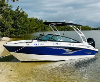 A blue and white Monterey rental deck boat from Port O Call Marina moored along a mangrove-lined sandbar