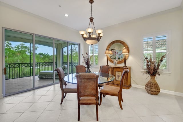 Bright dining room with glass table, leather chairs and chandelier beside sliding doors to a green garden view
Filename: TIB2830_103_8.jpg