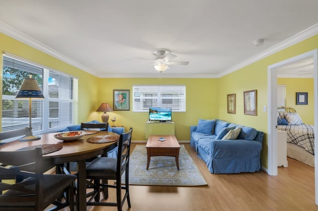 Bright yellow living room with blue slipcovered sofa, wood dining table and ceiling fan in a vacation rental
Filename: ON780_22_7.jpg
