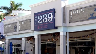 The 239 Naples storefront with navy sign, Local Grown and Local Raised panels, and string lights over the open patio