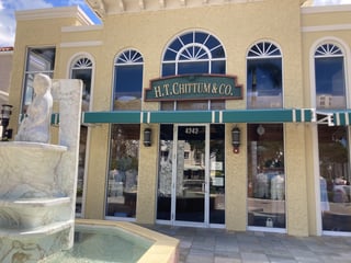 H.T. Chittum & Co. storefront with arched windows, green awnings and a marble fountain out front
