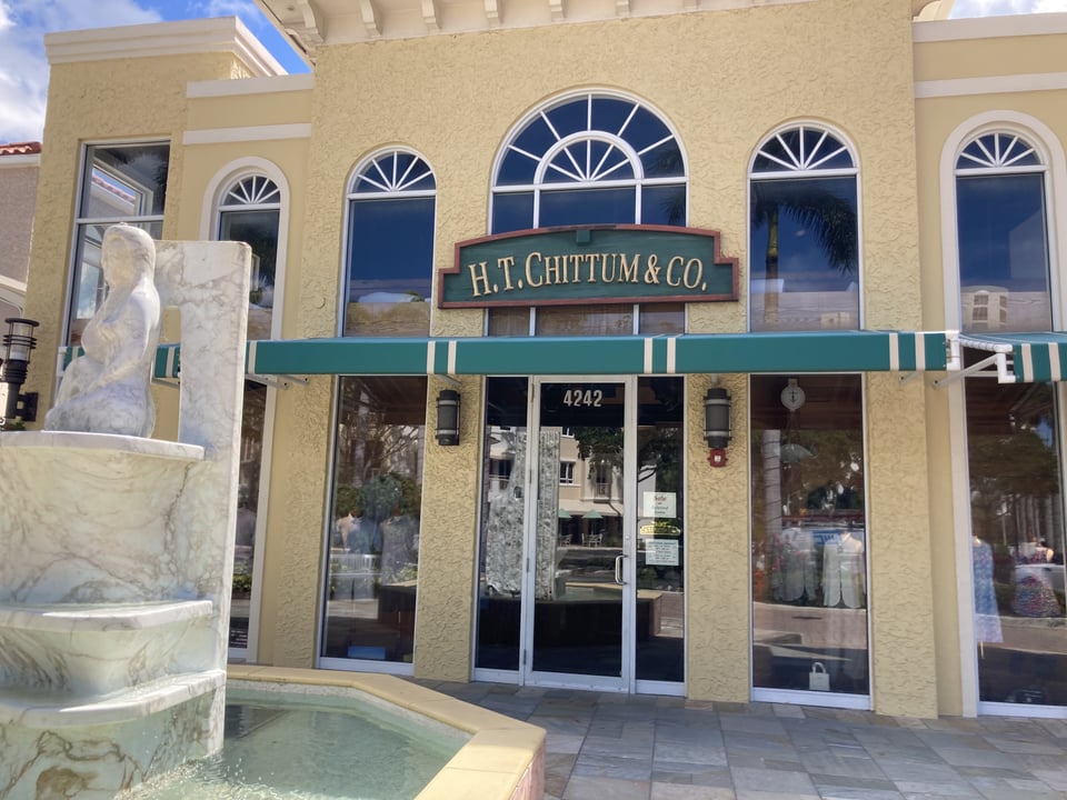 H.T. Chittum & Co. storefront with arched windows, green awnings and a marble fountain out front