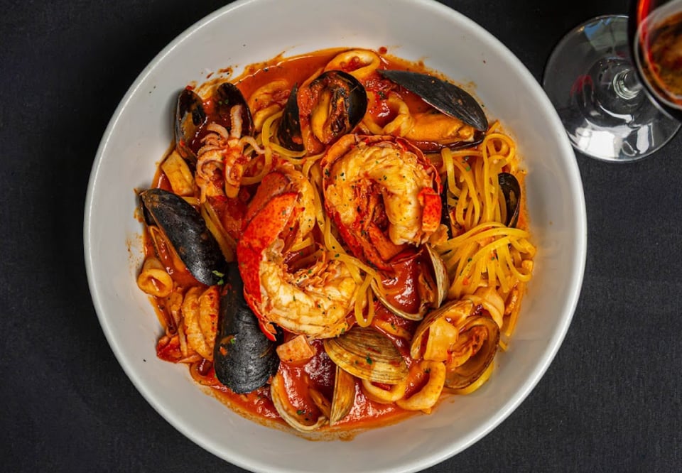 Bowl of seafood linguine with lobster, mussels, clams and calamari in rich tomato sauce