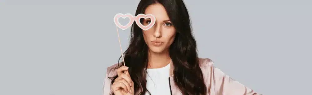 A buyer agent holding heart-shaped glasses, symbolizing enthusiasm and readiness for a buyer agent appointment.