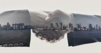 eXp Realty Revenos - eXp Affinity. A hands shaking with a city skyline