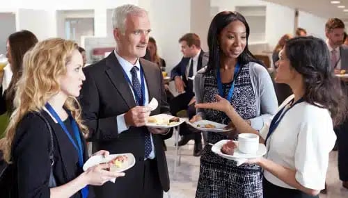 Group of professionals networking at an event, emphasizing the importance of networking opportunities in brokerage interview