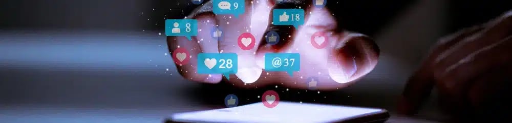 Person interacting with social media icons on a smartphone, illustrating real estate agent marketing mistakes.