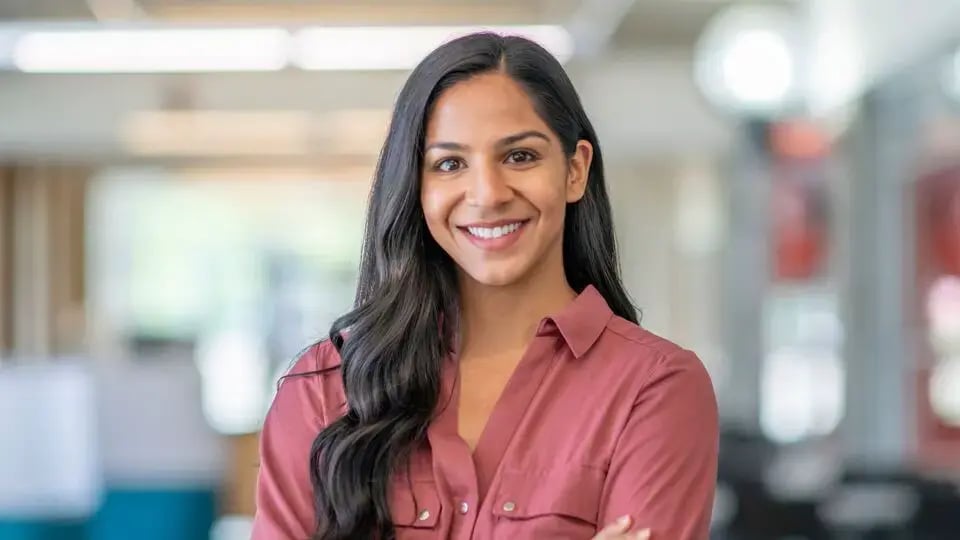 A happy realtor standing with her arms crossed
