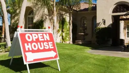 "Open House" sign in front of a welcoming, sunny home,