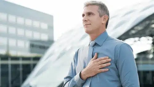  A buyer agent with a hand over his heart, signifying a pledge to serve clients with integrity.