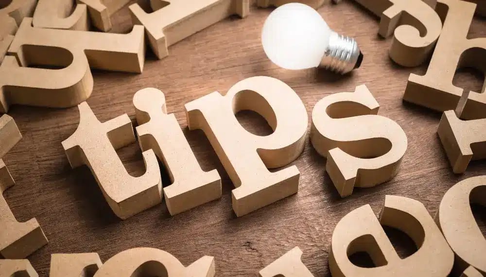 Wooden letters spelling 'tips' with a glowing lightbulb, symbolizing innovative and bright ideas for conducting a successful