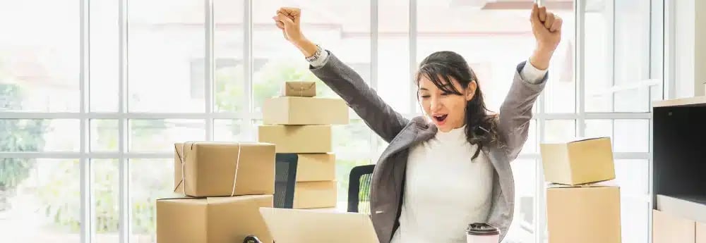 Real Estate Agent Marketing - Happy home seller celebrating successful sale with packed boxes in the background
