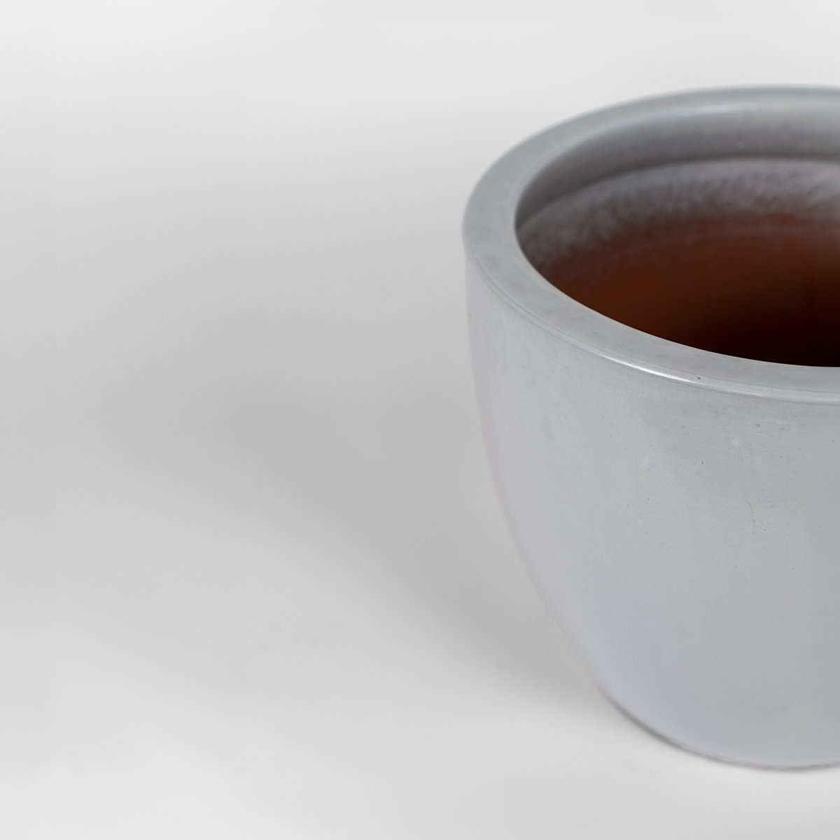 Ceramiczna donica Egg, biała, ręcznie wypalana terakota, z otworem drenażowym.