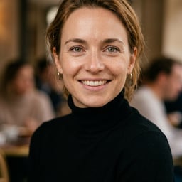 Professional AI LinkedIn headshot in Fitted black turtleneck (women's relaxed fit) on Cafe (warm professional)