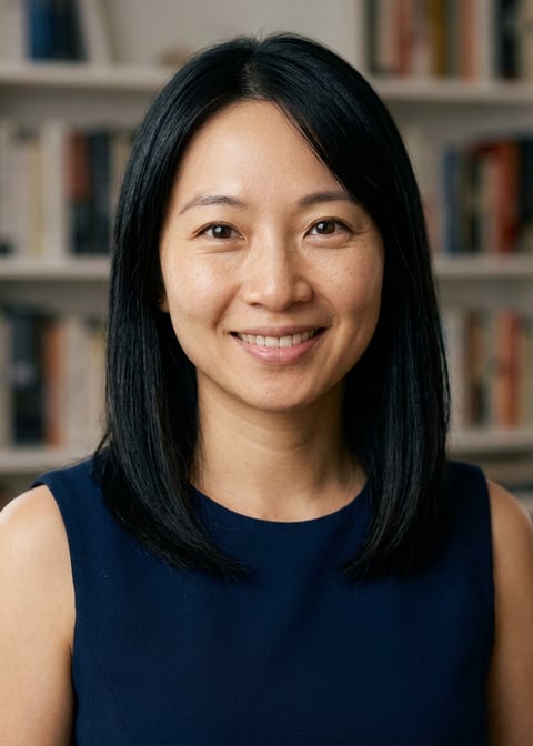 Professional AI LinkedIn headshot in Navy blue sleeveless dress on Bookshelf (thought-leader)