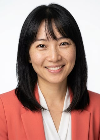 Professional AI LinkedIn headshot in Coral blazer over white blouse on White / Pure White Studio