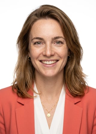 Professional AI LinkedIn headshot in Coral blazer over white blouse on White / Pure White Studio