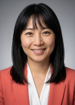 Professional AI LinkedIn headshot in Coral blazer over white blouse on Neutral Gradient / Light Grey