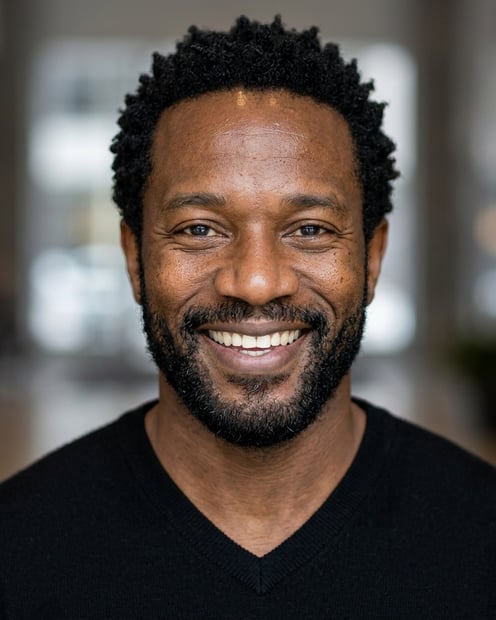 Corporate Lobby · Black v-neck sweater headshot example
